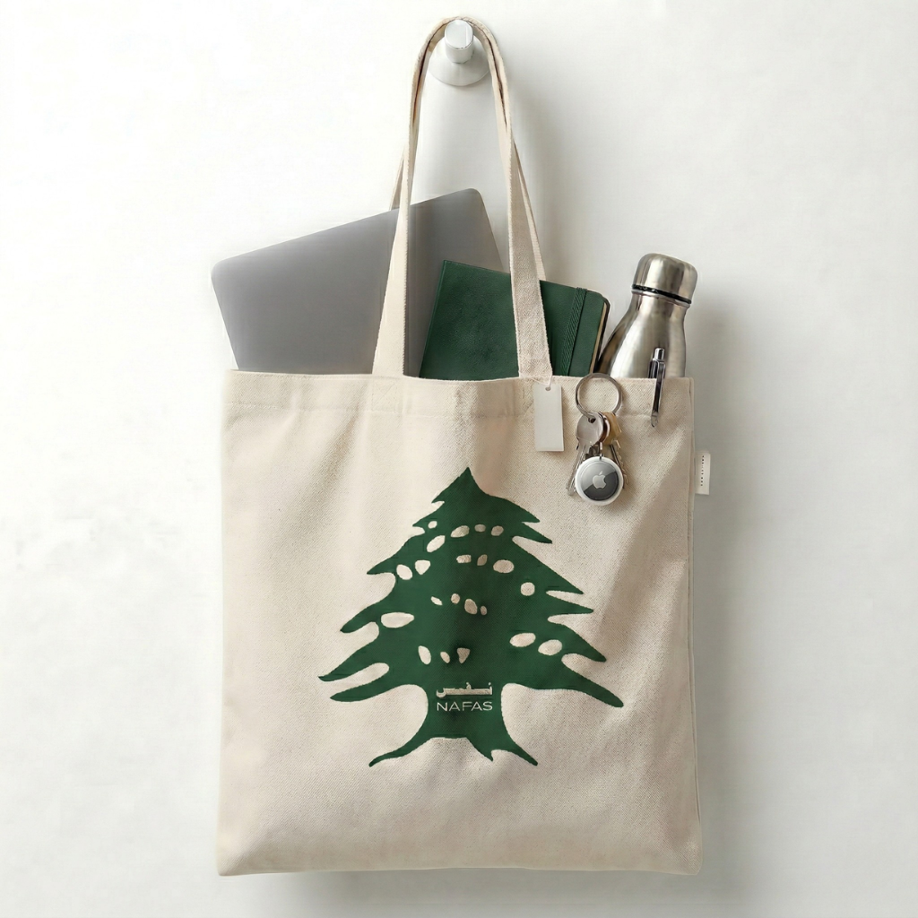 Close-up Lebanese Cedar print on Nafas cotton tote bag filled with daily items.