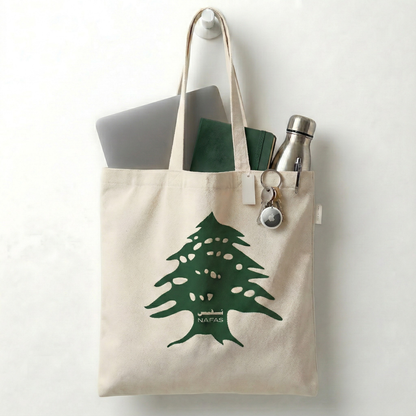 Close-up Lebanese Cedar print on Nafas cotton tote bag filled with daily items.