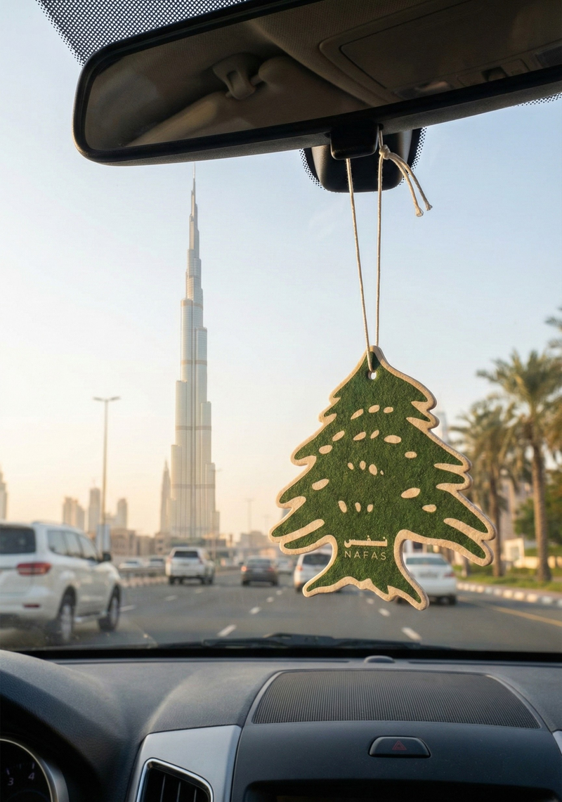 Burj Khalifa in Dubai seen from inside a car during the day with a Nafas Lebanese cedar air freshener hanging from the rearview mirror