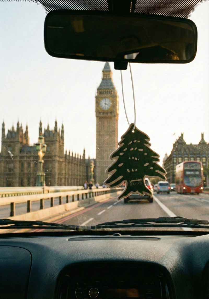 Big Ben and the Houses of Parliament in London seen from inside a car with a Nafas Lebanese cedar air freshener hanging from the rearview mirror