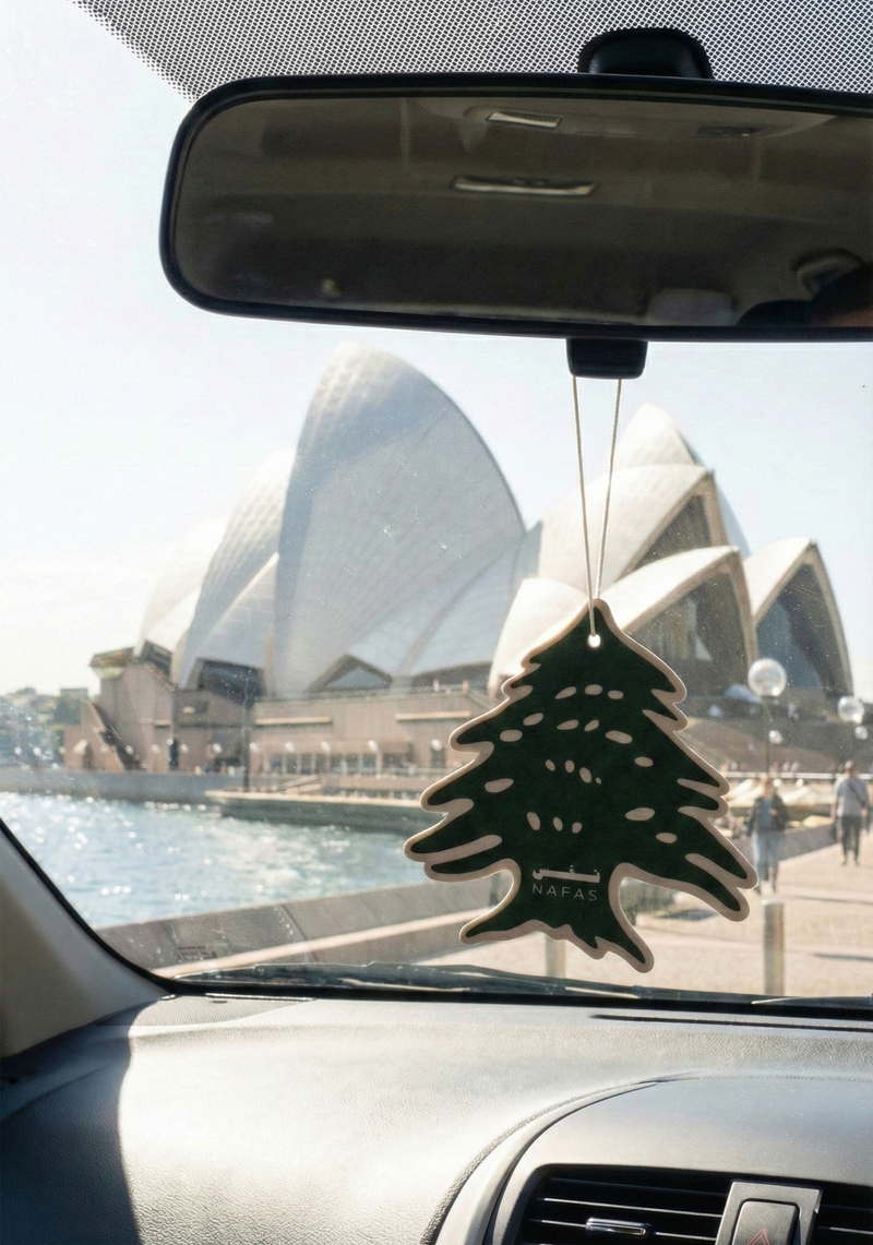 Sydney Opera House seen from inside a car during the day with a Nafas Lebanese cedar air freshener hanging from the rearview mirror