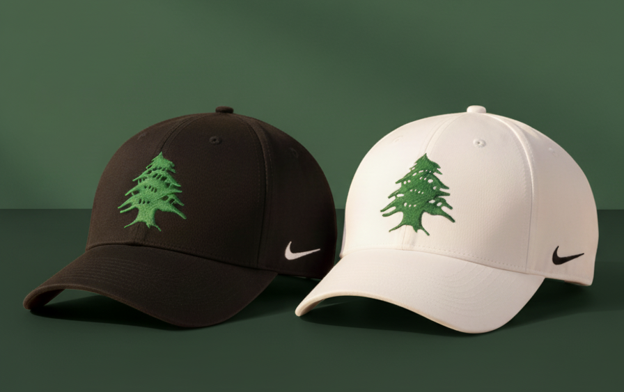 Two Nike baseball caps, one black and one beige, with embroidered nafas Lebanese cedar logos on a dark green background.